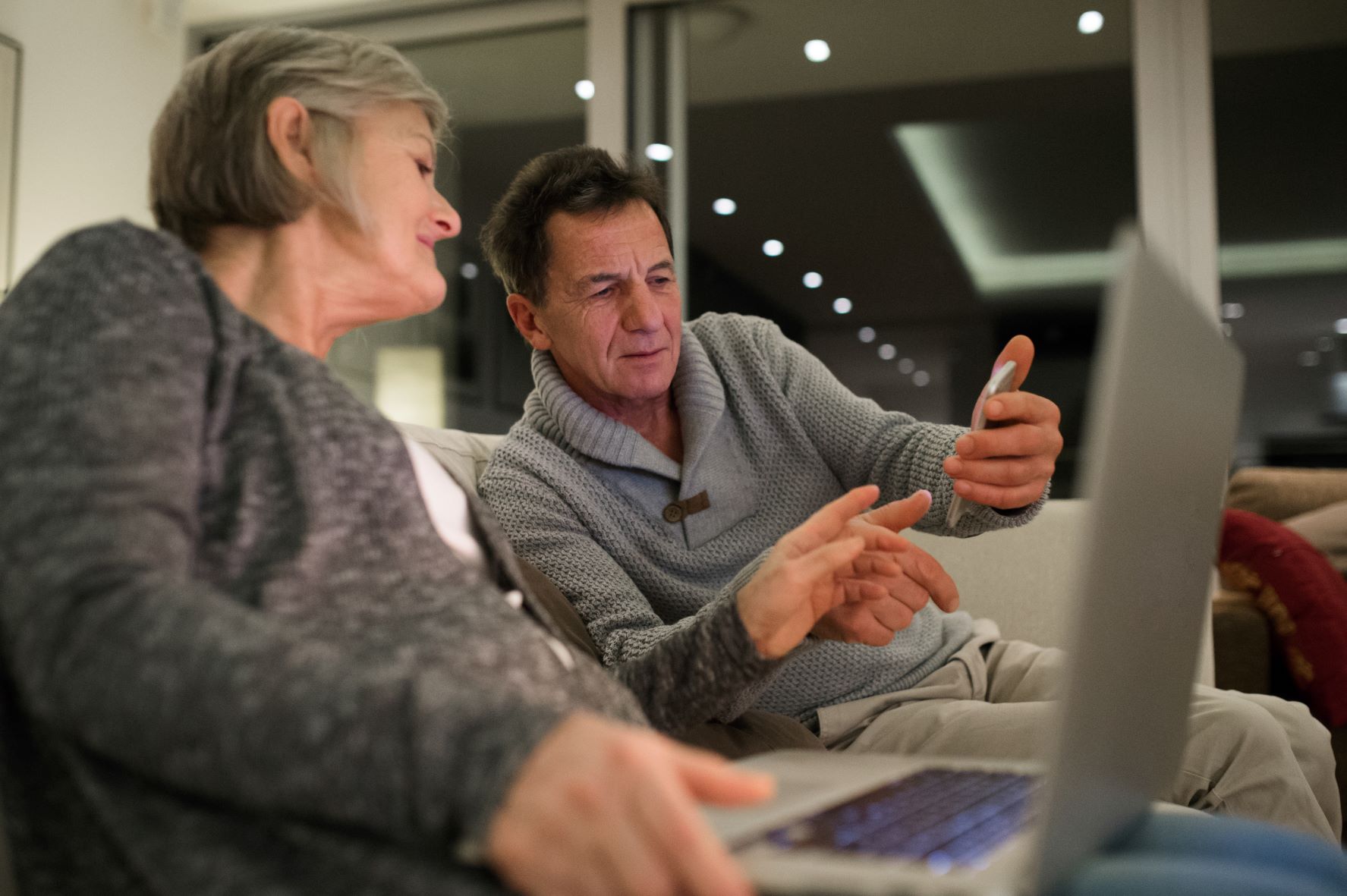man and woman looking at electronic devices